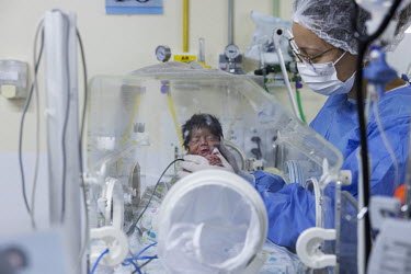 Physiotherapist Manoella Dias Barbosa cares for a newborn Yanomami baby in the ICU at the Nossa Senhora de Nazareth Maternal and Child Hospital in Boa Vista. The Yanomami have been going through an un...