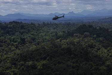 An IBAMA ( Brazilian Environmental Protection Agency) helicopter carrying members of the Special Inspection Group flies over the Uraricoera River on the border of the Yanomami Indigenous Land during a...