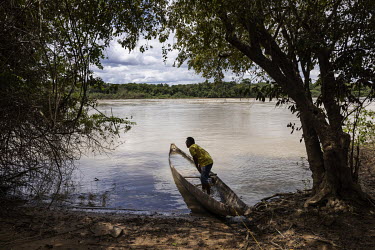 The Macuxi leader, Alexandre Apolinario, observes a boat carrying illegal miners along the Uraricoera River near the Boqueirao Indigenous Land. According to the indigenous people the community has bee...