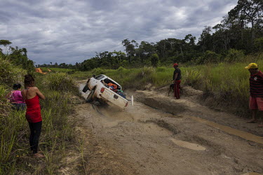 Miners ( garimpeiros ) and others fleeing illegal mining operations in Yanomami Indigenous Land following a crackdown by the new government watch as the pickup truck transporting them from a clandesti...