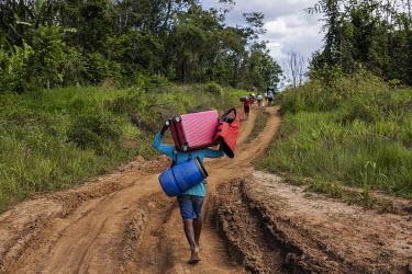 Illegal miners ( garimpeiros ), who left the Yanomami Indigenous Land, walk carrying their belongings along the road that links the port of Arame, on the banks of the Uraricoera River, to the village...