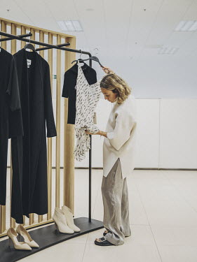 Maria Rolandi (Senior buyer, womens wear) inspects a Zara dress at the headquarters of multinational clothing company Inditex.