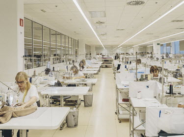 Employees work on stitching and embroidery in the womens wear department at clothing company Inditex.