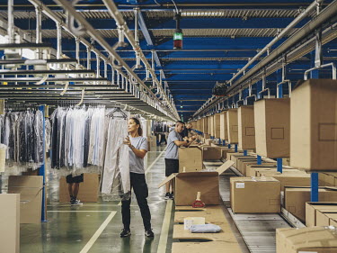 Employees pack boxes with garments in the logistics centre of multinational clothing company Inditex