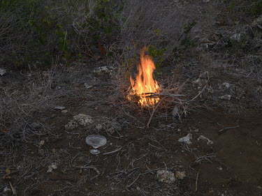 A fire and some incense burned as offerings at the entrance to a cave inhabited by bats, where locals believe that various kind of spirits also dwell.