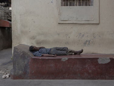 A homeless man sleeping in a street. Homeless people were targeted and often beaten and even killed during the major wave of panic that occurred on both Unguja and Pemba Island in 1995, when they were...