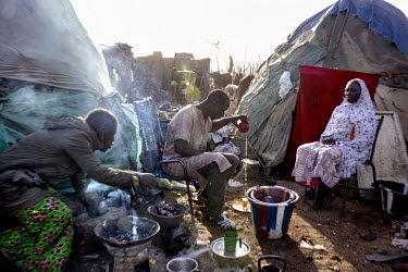 A man making tea while sat outside a group of decrepit shelters in the Faladie camp for displaced persons where 3,600 people are crammed together after fleeing attacks in the centre of the country. 80...