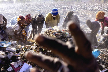 People search through a waste dump looking for anything they can sell to raise money to enable their survival. They live in the Faladie camp, beside the rubbish tip, for displaced persons where 3,600...