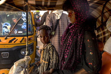 A Fulani woman and her child travel in a vehicle from the city market back to their encampment.