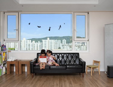 Children watching a cartoon on a tablet computer in their family apartment.Stitched Photograph