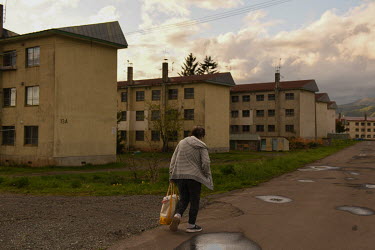 A local resident walks in front of apartment buildings where most of the rooms are empty. Yubari has the highest average age of any town in Japan. Among 6962 residents as of May 2022, 3718 people are...