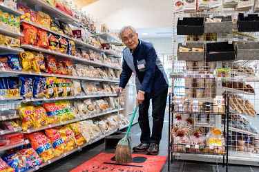 Hideyoshi Araki (72) sweeps the floor at the Lawson convenience store where he is employed.