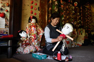 Tsukimi Ayano making a doll in the form of an elderly woman at her home in the hamlet of Nagoro. Tsukimi Ayano started making scarecrows to protect her field from crows in 2002. Since then she has bee...