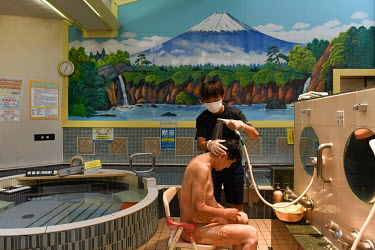 Jiro Tajima (88) is helped in washing his body at the 'Shinseiyu' bathhouse that opened in 1952 as a bathhouse for local residents. Since 2003, the facility has been used as a day time service for the...