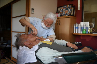 Shitsui Hakoishi (106) gives a haircut and shave to a 92-year-old customer, Chikara Ogane, who has been coming to Hakoishi's home for his hair cuts since she began her business 70 years ago. Every mor...