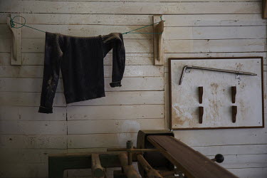 A jumper, speckled with sawdust, hangs in a workshop.