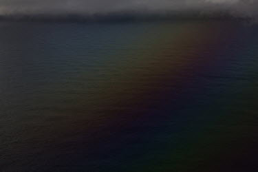 A mysterious rainbow reflection on the water's surface in a bay close to the airport.