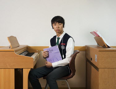 A 15-year-old student sits at a keyboard in a music class at the Shinil High School. Stitched Photograph