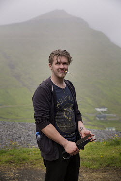 Olavur, 22, poses for a portrait while helping a relative with the sheep-shearing in the mountains. Olavur dreams of building a house for himself. 'Faroese men are traditional, but the women are more...
