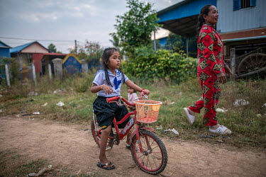 Ren Samnang (7), who was born with severe bilateral clubfoot, rides her bicycle near her family's home. Samnang's treatment was interrupted due to the family's financial constraints and the COVID-19 p...