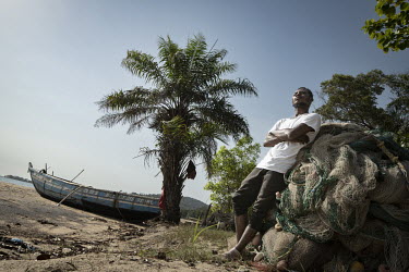 Fisherman Hassan Kargbo (26) in front of his boat on Black Johnson Beach, south of Freetown. He used to take home two million Leones per catch, now he is lucky to make 200 and he blames Chinese commer...