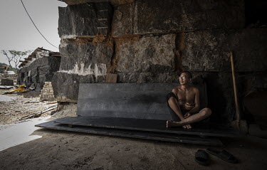 An ex-pat Chinese worker takes a break from quarrying granite for the Hongtai company, Comfort Bridge in the Western Area National Park.In Sierra Leone, businesses are taking advantage of poor legisla...