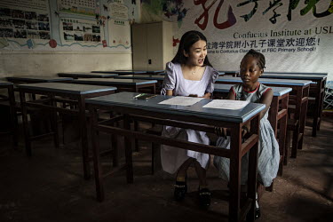 Sylvia, a Chinese teacher from the Confucius Institute with student Aisha who is learning a Chinese opera for a competition at the Fourah Bay College Primary School.