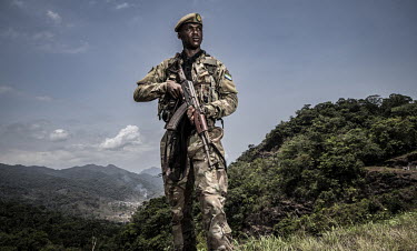 A soldier stands guard above Guma Dam in the heart of the Western Area National Park.In Sierra Leone, businesses are taking advantage of poor legislation, feeble enforcement and high levels of corrupt...
