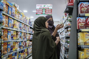 Women examine jars of imported baby food while shopping at the Hayat Market supermarket, on one of the newest commercial streets in the Wadajir district.