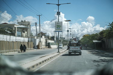 Security guards on patrol the city's streets in a Toyota pick up, seen from inside a vehicle travelling behind.