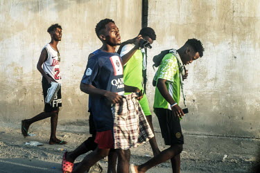 A group of young men walk along a street near the site of a football match near Lido Beach.