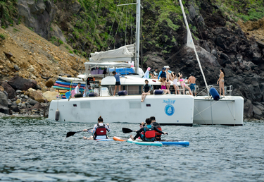 A catamaran loaded with tourists on an excursion and moored off the lee side of Turtle Island.