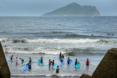 Surfers on the main beach at Wushi, near Toucheng, with Turtle Island on the horizon.