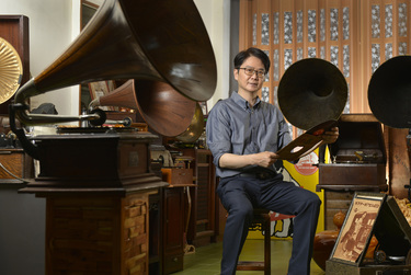 Record collector Dr Hsu Deng-fang sits amidst his collection of old gramophones located above his surgery.
