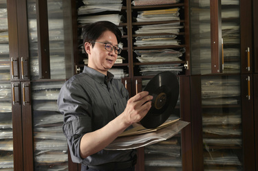 Record collector Dr Hsu Deng-fang examines one of the discs from his huge collection.