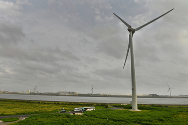 A tour bus is dwarfed by massive wind turbines near the Taipower Company's Chang-Yi Switching Station, on Taiwan's windswept west coast.