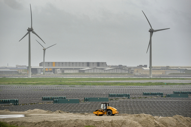 Wind turbines rise above a section of the Taipower Company's massive Changhua Coastal Solar Photovoltaic Field.