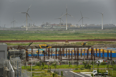 A field of wind turbines rises beyond an area of new construction in the vicinity of the Taipower Company's Chang-Yi Switching Station, on Taiwan's windswept west coast.