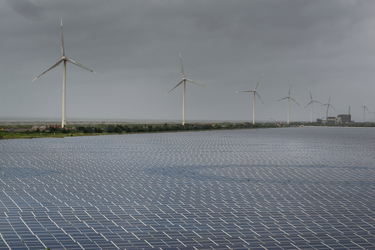 Wind turbines rise above a section of the Taipower Company's massive Changhua Coastal Solar Photovoltaic Field.