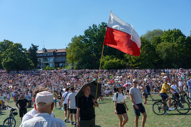 A man with a Polish flag walks among a large crowd who have came to watch the largest military parade ever held in post-communist Poland. The event involved 2,000 soldiers and 200 pieces of military e...