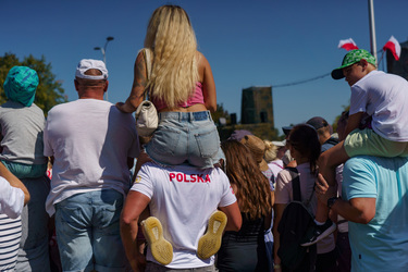 A woman sits on the shoulders of a friend as they stand among a large crowd who have came to watch the largest military parade ever held in post-communist Poland. The event involved 2,000 soldiers and...