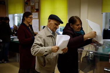 People place their voting forms into a ballot box after casting his vote at a polling station in a primary school for the 15 October 2023 parliamentary elections. The voter turnout is expected to be a...
