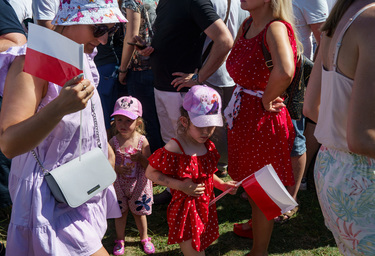 A woman and child holding Polish flags among a large crowd who have came to watch the largest military parade ever held in post-communist Poland. The event involved 2,000 soldiers and 200 pieces of mi...