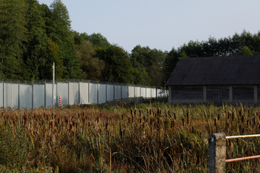 A small building stands beside the frontier fence that marks the border with Belarus.