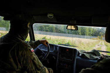 Soldiers drive a vehicle during a patrol along the border wall with Belarus.