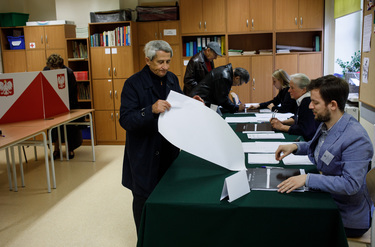 People signing in at a polling station in a primary school before voting in the 15 October 2023 parliamentary elections.