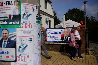 People passing a banner featuring PiS (Law and Justice) party leader Jaroslaw Kaczynski on the day of a PiS party rally in the town prior to the 15 October 2023 parliamentary elections.